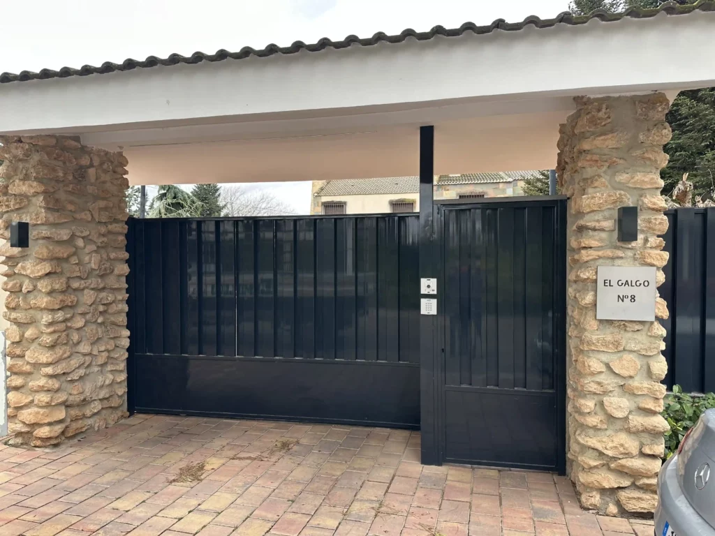 Puerta corredera automatizada de hierro en color negro, fabricada e instalada por Carpintería Metálica Emilio en Albacete